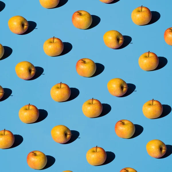 Açık mavi arka planda taze elma pop deseni. Isometrik sert gölgeler. Bio taze meyve suları kavramı