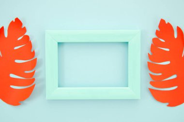 Kırmızı kağıt palmiye ile süslenmiş düz yatıyordu mockup boş mavi çerçeve mavi plastik bir çerçeve bırakır