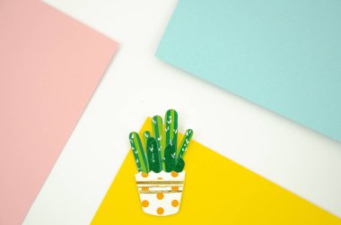 Düz kağıt kaktüs renkli bir potson bir pop tarzı pembe, sarı ve mavi arka plan