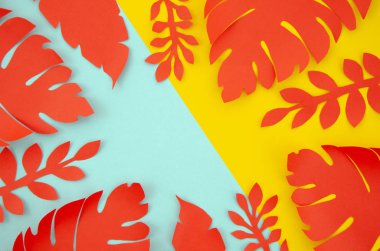 Üst görünüm Renkli Kırmızı, Sarı ve Turuncu Kağıt palmiye sarı ve mavi pop arka plan üzerinde çerçeve bırakır. Kopya alanı ile sonbahar konsepti