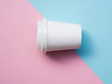 Üst görünüm küçük kağıt kahve fincanı pembe ve mavi pop arka plan izole. Beyaz espresso fincan ı mockup