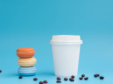 Renkli makaronyapılmış bir piramit ile Mockup beyaz kağıt küçük espresso kahve fincanı. Mavi arka planda yan görünüm. Metin için Boşluk Kopyalama
