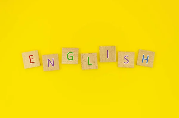 Плоское английское слово из деревянных блоков с буквами, научитесь говорить по-английски — стоковое фото