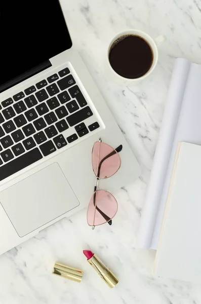Ainda vida de mulher de moda. Visão superior área de trabalho feminina com laptop, batom, chá e óculos de sol rosa. Tiro vertical — Fotografia de Stock