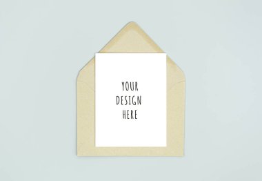 Kraft kahverengi kağıt zarf şablonu ile boş beyaz kart metin için kopya alanı ile alay. Gri üzerinde yalıtılmış üst görünüm posta