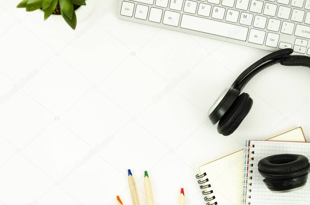 Top view frame mockup desktop with spiral notepads, plant, earphones, keyboard and stationary