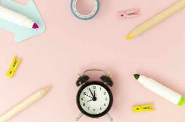 Üst görünüm çerçeve okul kırtasiye ve pembe bir arka plan üzerinde siyah çalar saat. Metin için alan kopyalayın. Okul konseptine geri dön