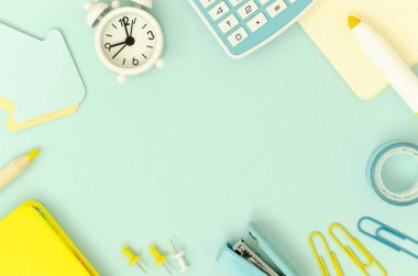 Düz döşeme çerçeve okul kırtasiye, hesap makinesi ve açık mavi arka plan üzerinde beyaz çalar saat. Metin için alan kopyalayın. Okul konseptine geri dön
