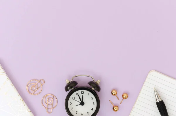 Marco plano con papelería de oro rosa, pluma y cuaderno, despertador negro. Burla con espacio de copia —  Fotos de Stock
