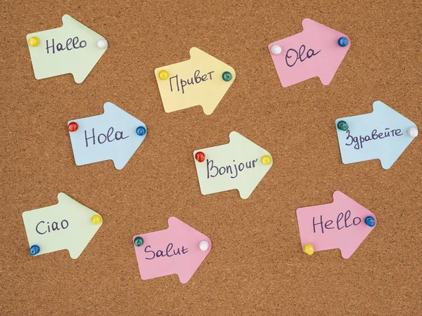 Изучение нового языка. Рукописные флеш-карты с Hello на других языках, прикрепленные на пробку — стоковое фото