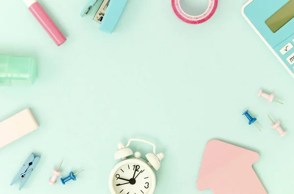 Marco maqueta hecha de papelería de oficina, calculadora y reloj despertador blanco sobre un fondo azul claro. Copia espacio para texto. Regreso al concepto escolar —  Fotos de Stock