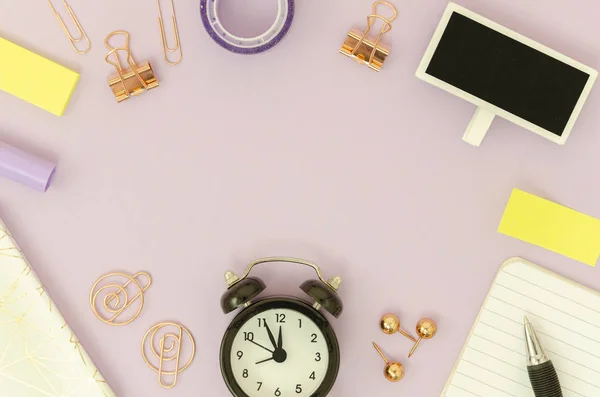 Marco de vista superior con papelería de oro rosa, pluma y portátil, reloj despertador negro. Mockup escritorio rosa femenino con espacio de copia —  Fotos de Stock