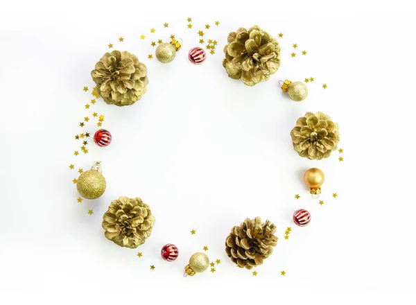Christmas circle wreath composition made with pine cones, golden decorations and xmas balls on white background. Flat lay, top view, copy space