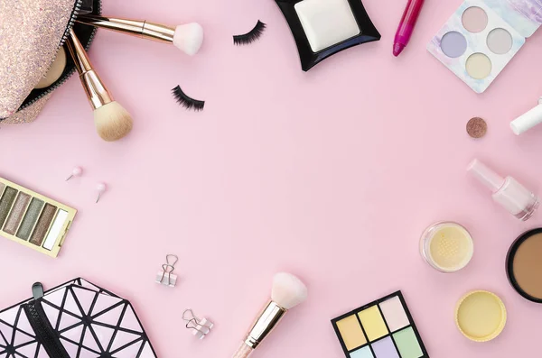 Vista superior colorido quadro mockup com vários produtos de maquiagem em um fundo rosa com cópia spoace. Conceito de mesa de trabalho feminino — Fotografia de Stock
