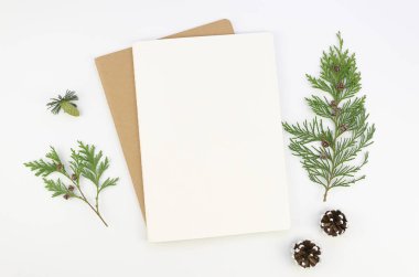 Üzerinde kürk ağacı dalları olan el işi kâğıdı bir zarfın üzerinde sahte Noel tebrik mektubu, beyaz arka planda düz bir tabaka. Harf metni için kopyalama alanı kullan