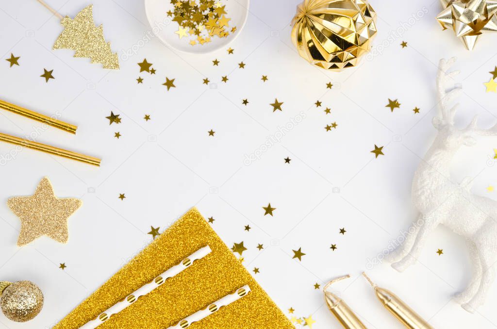 Top view Winter Christmas frame made of golden xmas tree decorations on a white table background. Holiday background with copy space for Happy New Year text