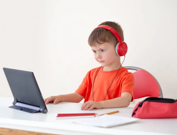 Çocukları çevrimiçi öğrenme zorluğu. Tablete bakan bir konferans öğretmenini anlamayan bir çocuk. Kulaklık takıyor. Çevrimiçi öğrenme. Evde E-oku. — Stok fotoğraf