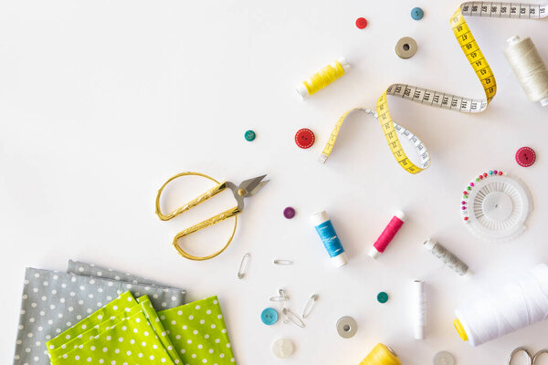 Sewing time. Tools for cutting, sewing on a white background. Mess at the seamstresss workspace