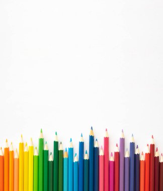 Okula dikey sınır çerçevesi. Fotokopi alanı olan beyaz arkaplandaki renkli kalemler. Düz yatıyordu