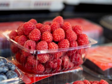 Taze meyve kavramı. Market raflarındaki ahududu dolu sepeti kapat.