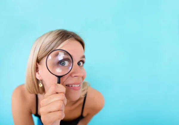 Datos privados y maqueta de espionaje. Mujer joven curiosa mirando a través de una lupa sobre fondo de color. Copiar espacio — Foto de Stock