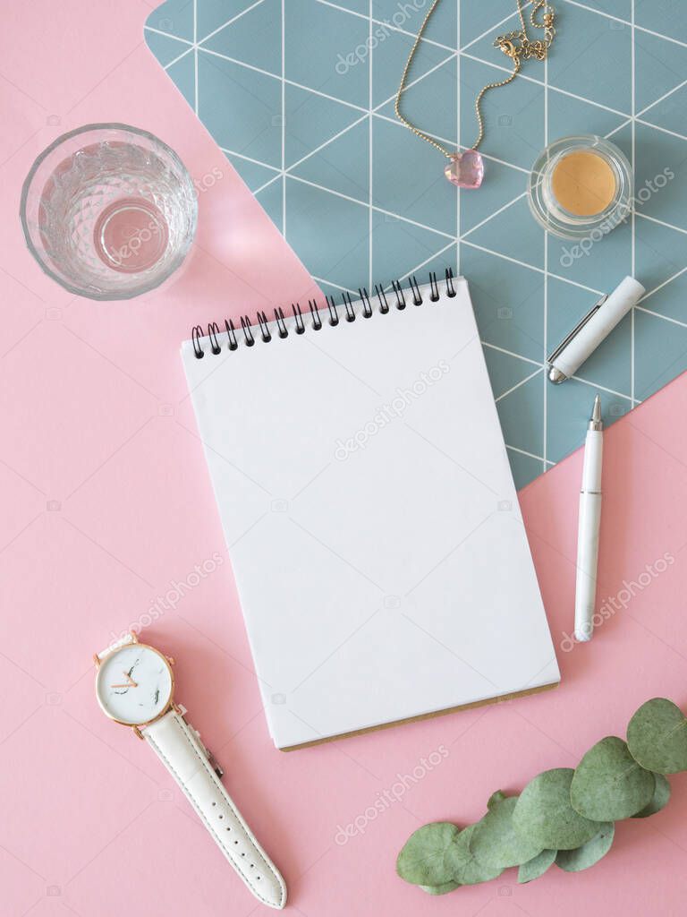 Womens notes mockup. Vertical flat lay mockup with a notebook, watch, glass of water on a pink background
