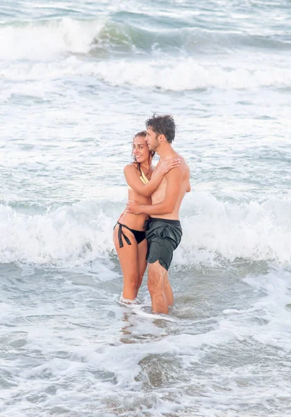 Concepto vacaciones de verano. Joven mujer y hombre abrazándose en el mar — Foto de Stock