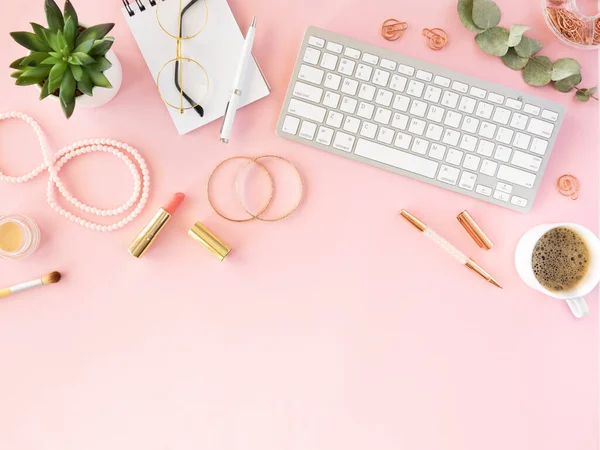 Feminino desktop moda mulheres flat lay. Top acessórios vista, cosméticos e jóias, xícara de café e teclado em um fundo rosa. Espaço de cópia — Fotografia de Stock