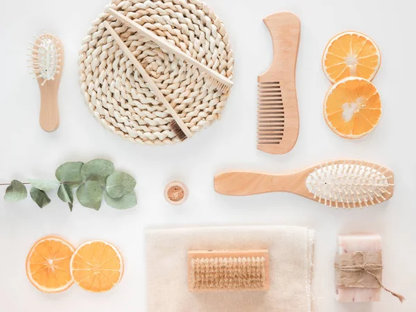 Sıfır atık ahşap banyo aksesuarı konsepti. Üst görünüm sabun, portakal kamaları ve beyaz arkaplan üzerinde okaliptüs dalı