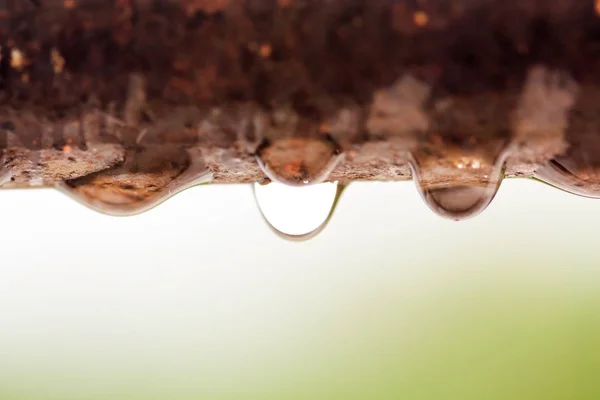 Paslı bir demir çubuk üzerinde su damlacıklarının kapatılması