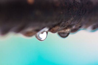 Odak arka plan renkli bir paslı demir çubuk üzerinde su damlacıkları closeup