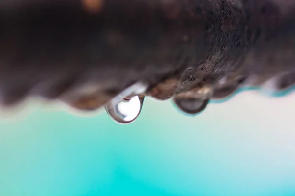 Odak arka plan renkli bir paslı demir çubuk üzerinde su damlacıkları closeup