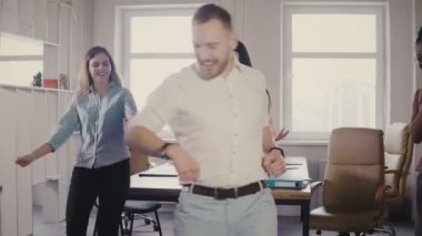 Genç erkek yönetici komik bir zafer yapıyor dans, beyaz casual ofis parti, iş başarı 4 k kutlamak