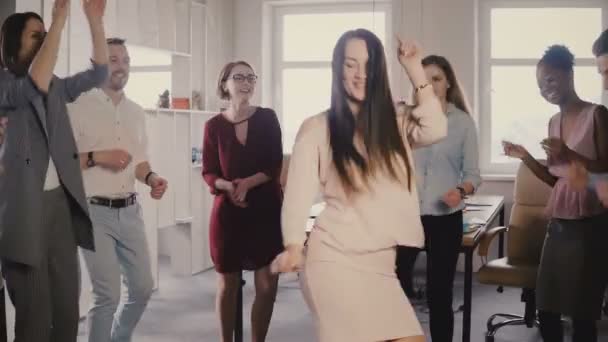 Happy Caucasian female executive doing funny victory dance. Mixed race colleagues celebrate business success together 4K — Stock Video