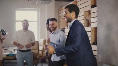İş başarı 4 k kutluyor geçici ofis partisinde meslektaşları ile dans mutlu Afrika Amerikalı yönetici.