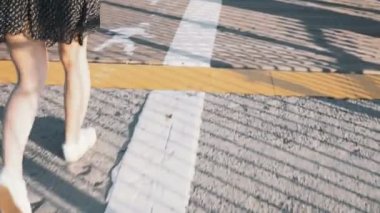 Kamera kadın bacakları asfalt ve güzel ince gölgeler 4 k ile kaplı çizgili ahşap yol boyunca yürüyüş izler.