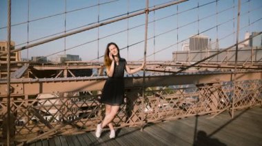 Çekici Avrupa Genç kadın inanılmaz Brooklyn Köprüsü'nün görünümü güzel yaz gününde 4 k ayakta telefon, söz