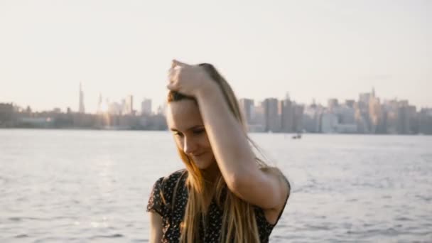 Портрет щасливі усміхнений кавказьких вагітна дівчина на камеру, Надівши сонцезахисні окуляри на горизонт Нью-Йорка пляж заходу сонця 4 к. — стокове відео