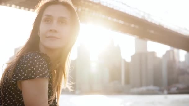 Retrato en cámara lenta de la pacífica chica caucásica con el pelo dorado mirando a su alrededor, disfrutando de la vista panorámica de la puesta del sol de Nueva York . — Vídeo de stock