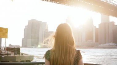 Bir nehir setin doğru koşma, atlama, silah New York City ağır çekimde heyecanlı raising mutlu kız arkadan görünüm.