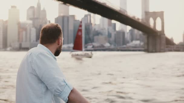 Succesvolle Kaukasische Freelance Zakenman Bedraagt Rivier Dijk Onder Brooklyn Bridge — Stockvideo