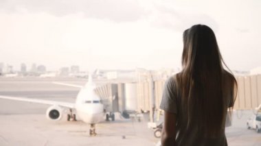 Genç Avrupa kız görüşmeler smartphone ve gülümsüyor, etraf Havaalanı terminal penceresi, uçak içinde belgili tanımlık geçmiş vasıl ara.
