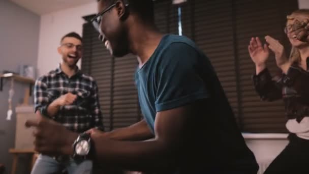 Lycklig African American ung man dansa tillsammans med vänner på casual multietniskt house party fest slowmotion — Stockvideo