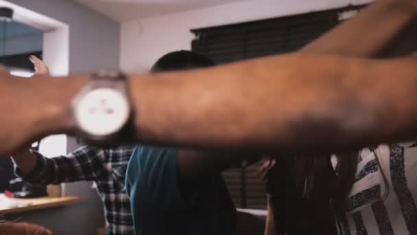 Succès afro-américain jeune homme d'affaires célébrant gagner avec des amis multiethniques, les étreignant au ralenti .