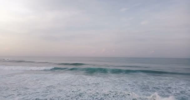 Drone panning esquerda para revelar o pôr-do-sol épico acima de altas ondas espumantes em belo oceano aberto. Panorama incrível da paisagem marinha . — Vídeo de Stock