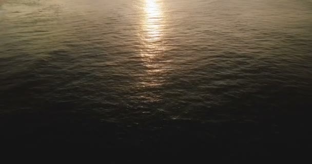海の壮大な夕日の反射の空中ショット湖面、カメラの傾きを熱帯海岸の素晴らしいスカイラインを明らかにするには. — ストック動画