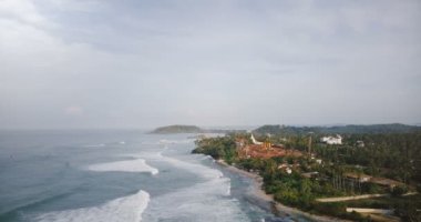 Dron güzel köpük deniz üzerinde yükselen dalgalar, şaşırtıcı lagün ortaya çıkarmak için kıyı şeridi ve bina inşaat alanı.