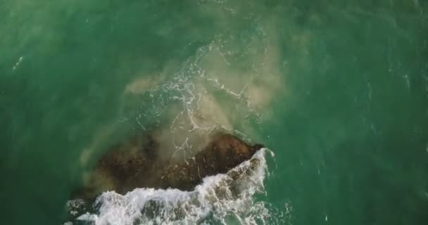 Drone aéreo tiro de bela onda verde oceano bater sobre uma pedra de recife de cais perto da costa, criando espuma branca bonita — Vídeo de Stock
