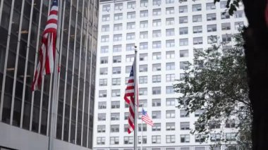 Yakın çekim cam bina gökdelenler ofisleri görünümünü. New York'ta rüzgarda sallayarak Amerikan Ulusal bayrakları.