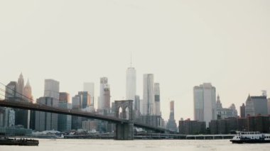 Güzel arka plan günbatımı Brooklyn Köprüsü ve New York cityscape manzarası bir kadeh. Nehirde 4 k geçirerek tekne.